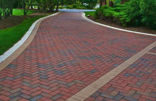 Beautiful brick paver driveway in herringbone pattern with red and brown tones
