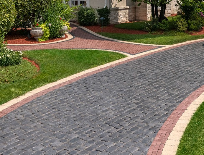 Cobblestone pattern paver driveway with red brick accents