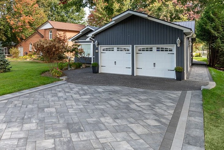 Paver driveway leading to garage with decorative borders