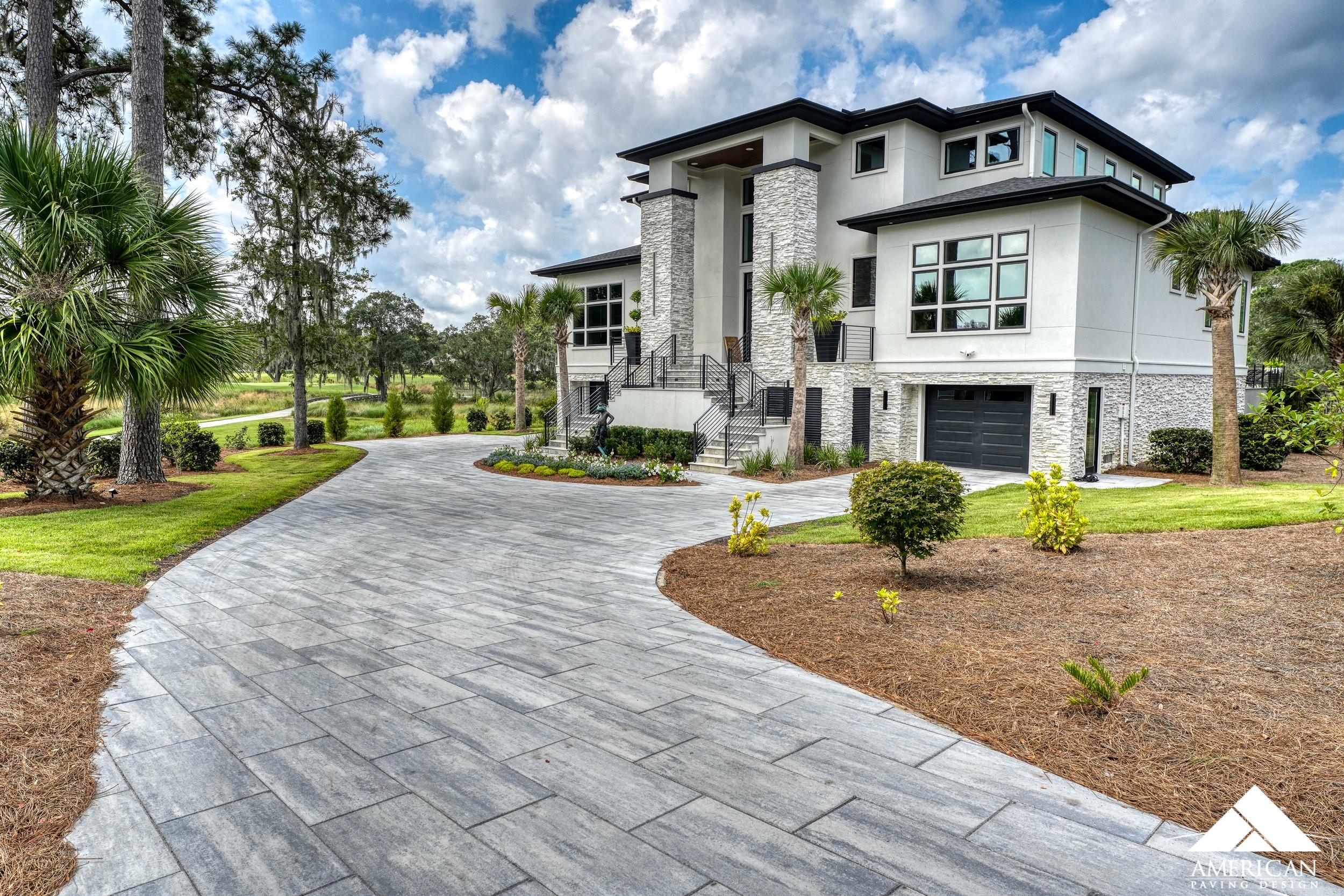 Modern gray concrete paver driveway with contemporary home