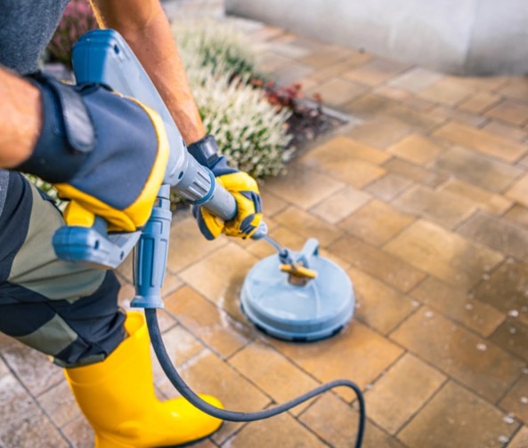 Professional power scrubber equipment in action cleaning paver surfaces with rotating brush system
