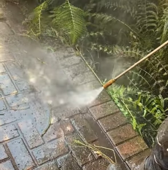 Detailed pressure washing process showing professional cleaning techniques on pavers