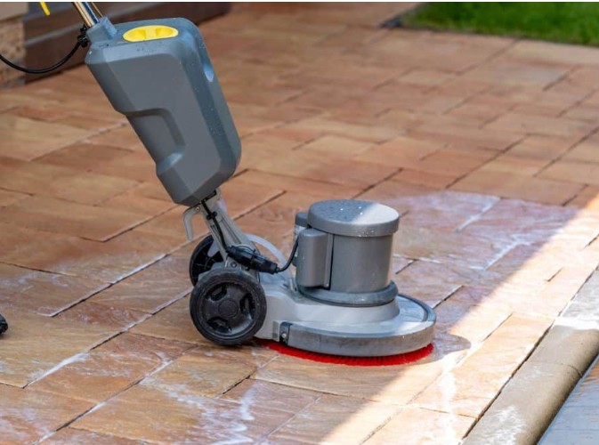 Professional-grade power scrubber machine used for deep cleaning paver surfaces