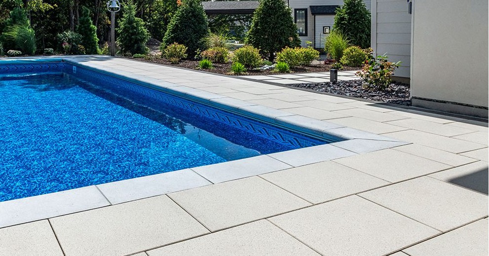 Clean Concrete Pool Deck with Landscaping - Professional Installation