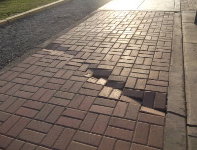 Broken paver driveway with missing sections and structural damage requiring comprehensive repair