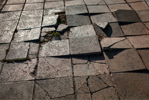 Broken pavers with surface cracks and structural damage across multiple sections